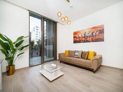 a living room with a couch and a table at Modern 1-Bed Escape with Large Terrace, Creek Beach Dubai in Dubai