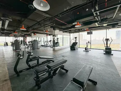 a gym with several treadmills and elliptical machines at Stylish JVC 1 Bed with Wraparound Balcony in Dubai