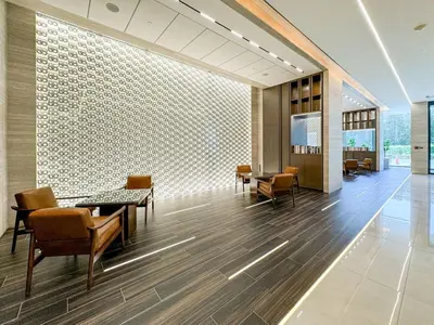 a lobby with tables and chairs in a building at Stylish JVC 1 Bed with Wraparound Balcony in Dubai