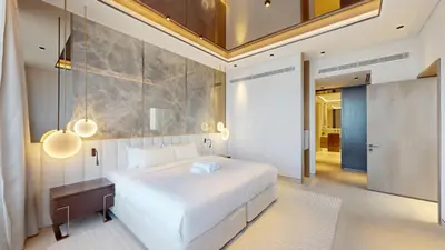 a bedroom with a large white bed and a ceiling at Palm Tower - Luxurious One Bed with Palm View in Dubai