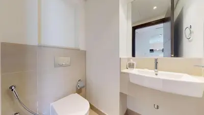 a bathroom with a sink and a toilet and a mirror at Creek Residences - One Bedroom with Creek View in Dubai