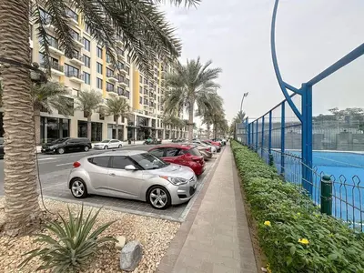 a row of cars parked in a parking lot at UNA Tower - Peaceful One Bedroom in Townsquare in Dubai