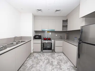 a kitchen with white cabinets and stainless steel appliances at Beach View family friendly unit in Dubai in Dubai