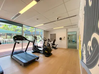 a gym with two treadmills and two exercise bikes at Stylish 2BR Apartment in Belgravia III A, JVC - Allsopp & Allsopp in Dubai
