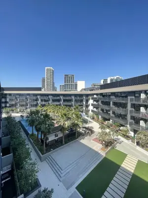 an aerial view of an apartment complex with palm trees at Stylish 2BR Apartment in Belgravia III A, JVC - Allsopp & Allsopp in Dubai
