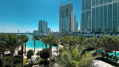 a view of a city with palm trees and buildings at Stylish 1BR City View at Vida Creek Beach in Dubai
