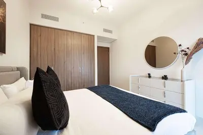 a bedroom with a large bed and a mirror at Stylish 1BR City View at Vida Creek Beach in Dubai