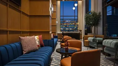 a lobby with blue couches and chairs and a bar at Stylish 1BR City View at Vida Creek Beach in Dubai