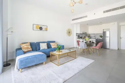 a living room with a blue couch and a table at Frank Porter - Lamtara 3, MJL in Dubai