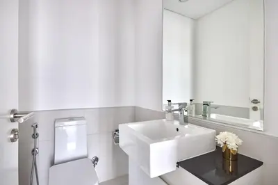 a white bathroom with a sink and a toilet at Frank Porter - Pulse Residence Park B3 in Dubai