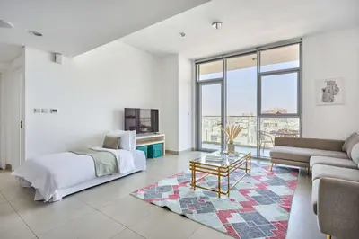 a white bedroom with a bed and a couch at Frank Porter - Pulse Residence Park B3 in Dubai
