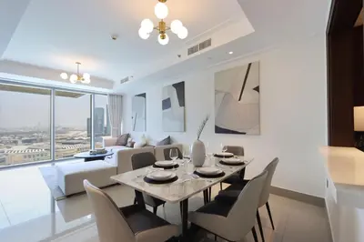 a dining room and living room with a table and chairs at 2BR with Iconic Burj and Dubai Fountain Views in Dubai