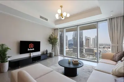 a living room with a white couch and a large window at 2BR with Iconic Burj and Dubai Fountain Views in Dubai