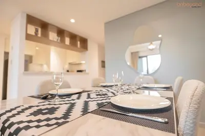 a dining room with a table with plates and wine glasses at Bnbeyond's Artistic Luxe Retreat with Burj Views in Dubai