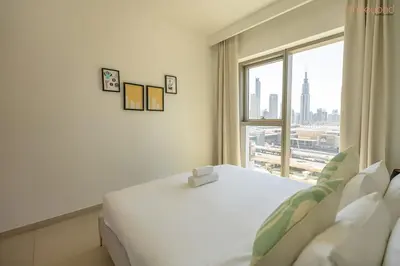 a bedroom with a large white bed and a window at Bnbeyond's Artistic Luxe Retreat with Burj Views in Dubai