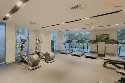 a gym with several treadmills and machines in a room at Bnbeyond's Sky-High Luxe with Above and Beyond Views in Dubai