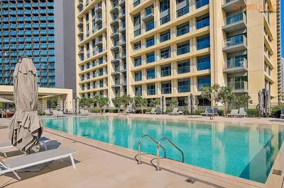 a large swimming pool in front of a large building at Bnbeyond's Sky-High Luxe with Above and Beyond Views in Dubai