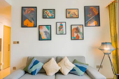 a living room with a couch and framed pictures on a wall at Bnbeyond's Sky-High Luxe with Above and Beyond Views in Dubai