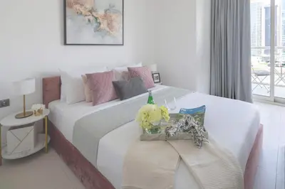a bedroom with a large white bed with flowers on it at Frank Porter - West Avenue in Dubai