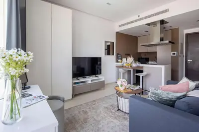 a living room with a couch and a tv at Frank Porter - West Avenue in Dubai