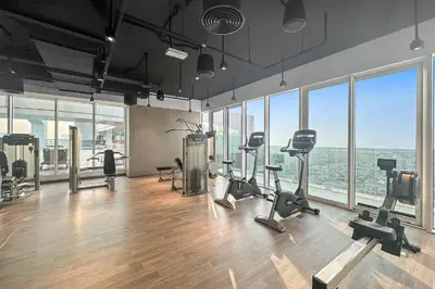a gym with treadmills and exercise equipment in a room with windows at Dubai Frame Views Steps from Metro & Sheikh Zayed Road in Dubai