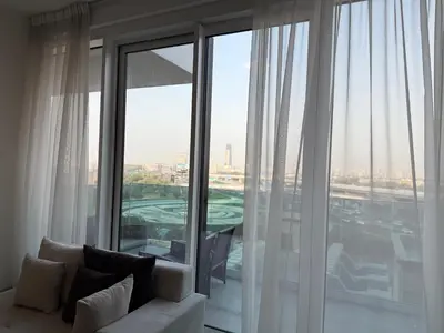 a living room with a white couch and a large window at Dubai Frame Views Steps from Metro & Sheikh Zayed Road in Dubai