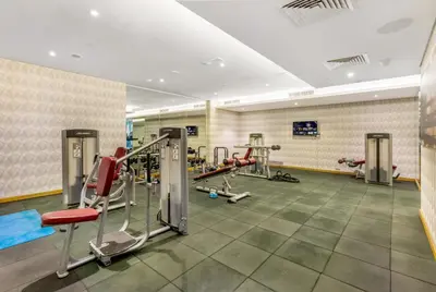 a gym with several tread machines in a room at Live the Dubai Dream Premium Flat in Business Bay in Dubai