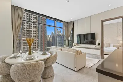 a living room with a table and chairs and a couch at Modern 1Bedroom w Burj Khalifa view in Peninsula in Dubai