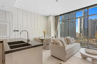 a kitchen and living room with a couch and a table at Modern 1Bedroom w Burj Khalifa view in Peninsula in Dubai
