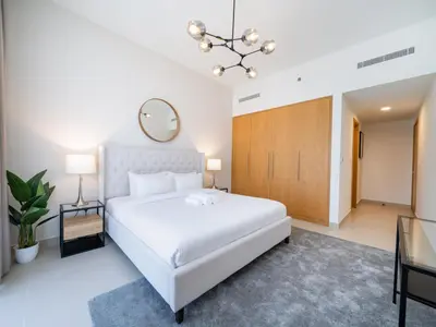 a bedroom with a large white bed and a mirror at Modern Downtown 2 Bed plus Maids with Full Burj View in Dubai