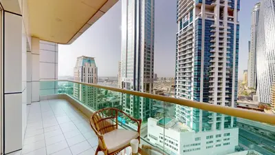 a balcony with a chair and a view of the city at Royal Oceanic - Bright Two Bed on the 14th Floor in Dubai