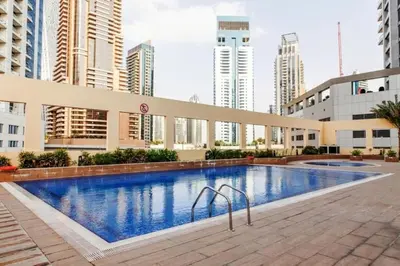 a large swimming pool in a city with tall buildings at Royal Oceanic - Bright Two Bed on the 14th Floor in Dubai