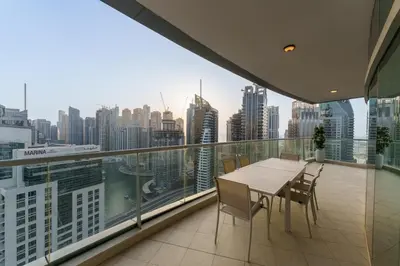 a balcony with a table and chairs and a city skyline at Exquisite 2-Bedroom with Panoramic Marina view in Dubai
