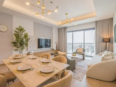 a dining room and living room with a table and chairs at TRPS - Central Park, City Walk, Al Wasl - 2BR Modern Residence - Elegantly Furnished to High Standards in Dubai