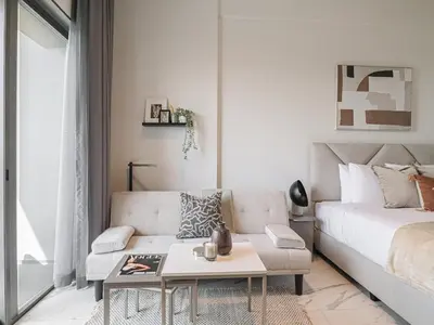 a living room with a couch and a coffee table at Welhome - Chic Studio with Balcony & City Views in Dubai in Dubai