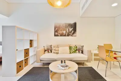 a living room with a couch and a table at Comfy Studio with Views Near Marina & Burj Al in Dubai