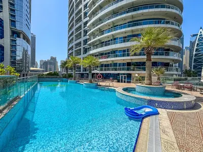 a swimming pool in front of a tall building at Comfy Studio with Views Near Marina & Burj Al in Dubai