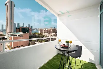 a balcony with a table and a view of the city at Luxury 1 Br Marina Near Tram Ain Sea View Balcony in Dubai