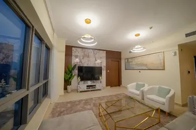 a living room with a couch and a tv at Stunning 4BR Apartment with Full Burj Khalifa and Fountain View in Dubai