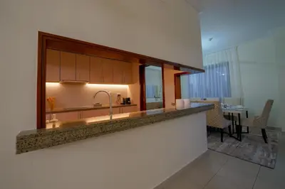 a kitchen with a sink and a dining room at Stunning 4BR Apartment with Full Burj Khalifa and Fountain View in Dubai