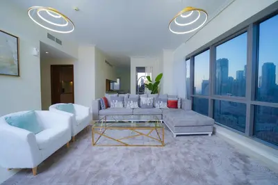 a living room with white furniture and a large window at Stunning 4BR Apartment with Full Burj Khalifa and Fountain View in Dubai