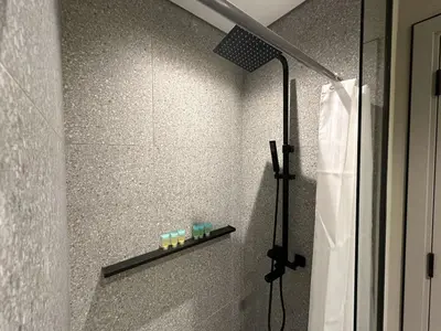 a shower in a bathroom with a shower curtain at Welhome - Elegant Studio with Skyline Views & Comfort in Dubai
