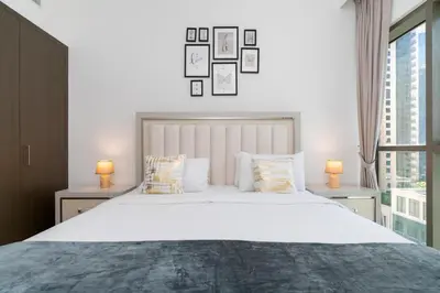 a bedroom with a large white bed with two lamps at Creek Side 18 I Harbor Views I in Dubai