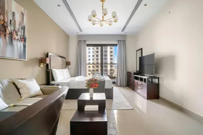 a living room with a couch and a bed at Stylish Downtown Studio in Dubai