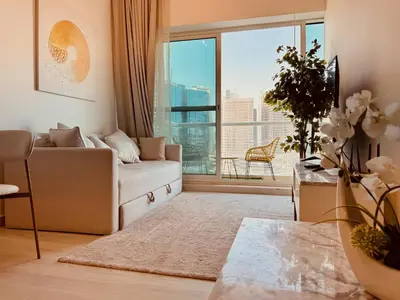 a living room with a couch and a large window at Canal View Comfort Business Bay in Dubai