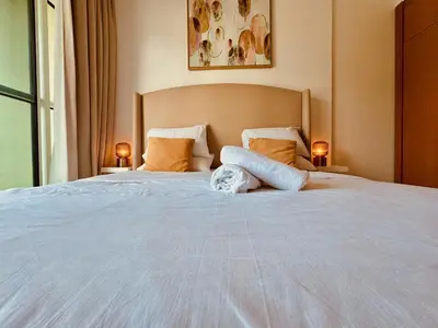 a bedroom with a large white bed with two lamps at Canal View Comfort Business Bay in Dubai