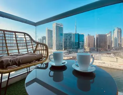 a table with two cups on a balcony with a view of the city at Canal View Comfort Business Bay in Dubai