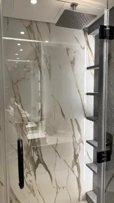 a bathroom with a marble wall with a glass door at Brand new fully furnished studio in Dubai