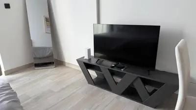 a flat screen tv on a black stand in a room at Brand new fully furnished studio in Dubai