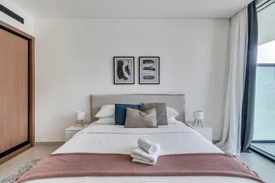 a bedroom with a large bed with two towels on it at GuestReady – Modern comfort in JVC in Dubai